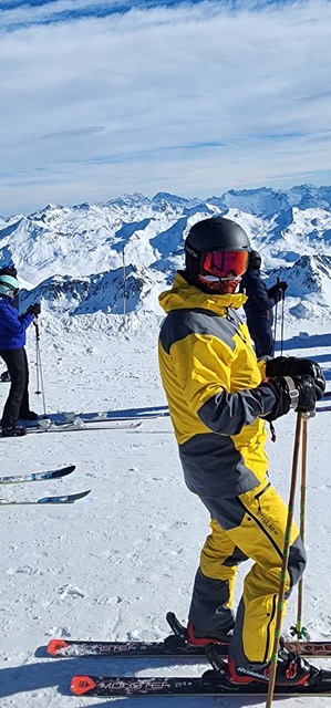 Mauricio skiing in the Alps, yellow and grey jacket